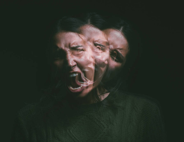 A haunted house is fiction, but a haunted mind...Studio shot of a young woman experiencing mental anguish and screaming against a black background - Foto, Imagem