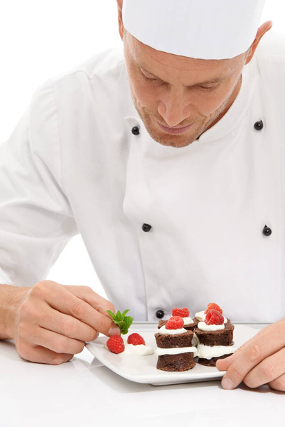 Cook, dessert and mint on sweet chocolate or berries on food by culinary chef with recipe on a plate in white studio background. Cooking, presentation and man or person making mini cakes as cuisine. - 写真・画像