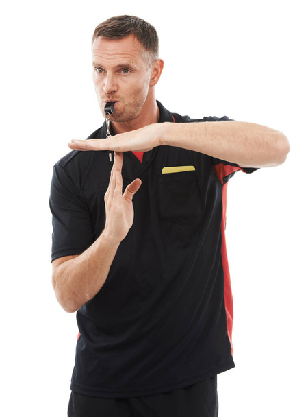 Sports, timeout and man referee in studio blowing a whistle for soccer match or training. Fitness, rules and mature male coach with hand football gesture or sign language isolated by white background. - Photo, image