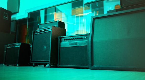 Vintage, retro and old speakers or music equipment in studio or room with neon blue light for entertainment. Stereo, record and audio tools or loudspeaker with volume and sound as 90s technology. - Foto, Bild