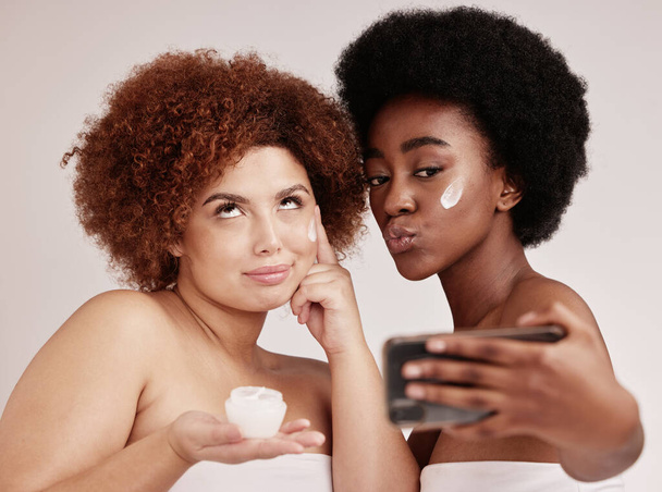 Skincare, funny and facial with friends and selfie for product, beauty and spa. Comic, phone and social media with black women and silly face photo with cream for health, makeup or wellness in studio. - Photo, image