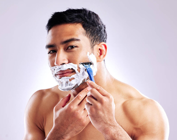 its entirely up to you what to do with your face. a handsome young man shaving his facial hair - Foto, immagini