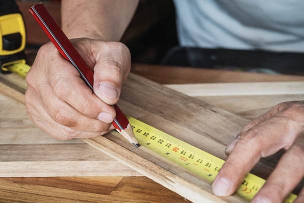 Cinta métrica con marcas de medidas lineales sobre fondo de madera, fabricante de bricolaje y concepto de carpintería. enfoque selectivo. - Foto, imagen