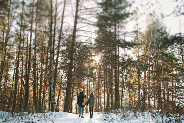 Young couple standing alone in winter forest - Foto, Imagen