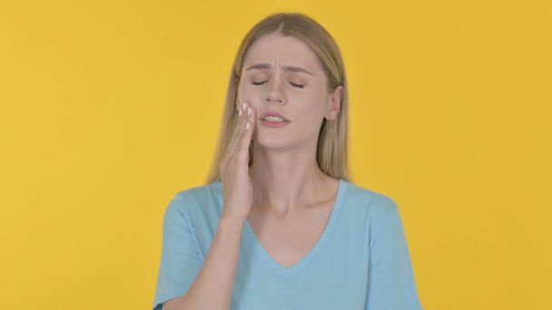 Casual Young Woman having Toothache on Yellow Background - Photo, image