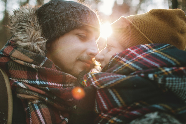 Young man hugs his girlfriend in winter forest - Foto, Imagen