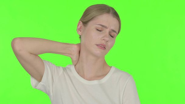 Случайная молодая женщина с болями в шее на зеленом фоне - Фото, изображение