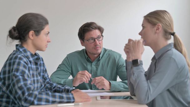Der Mann mittleren Alters im Gespräch mit Arbeitern bei einem Treffen - Foto, Bild