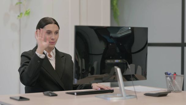 Joven empresaria hablando en videollamada en computadora de escritorio - Foto, imagen