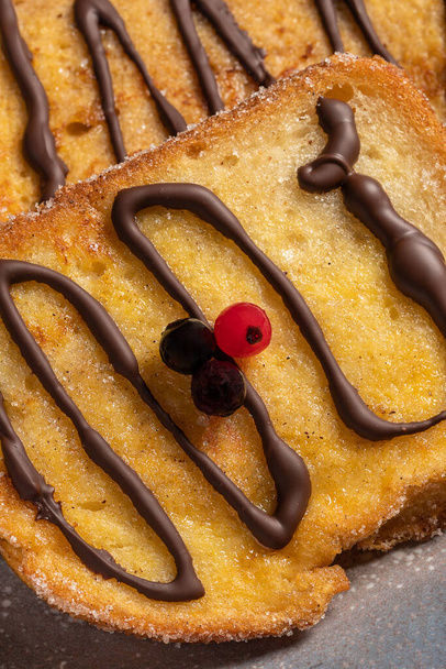 (Torrijas) Fried bread soaked in milk flavored with vanilla, cinnamon, lemon and egg with chocolate on a gray plate. Typical Easter sweet. Traditional festive cooking concept. Selective focus. - Fotografie, Obrázek