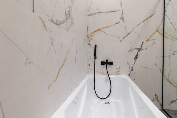 white acrylic bathtub in a modern interior of a new apartment - 写真・画像