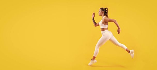 Woman jumping running banner with mock up copyspace. sport girl runner running on yellow background - 写真・画像