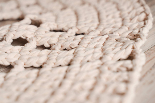 Szydełkowany dywan wykonany z beżowej przędzy makaronowej, z bliska - Zdjęcie, obraz