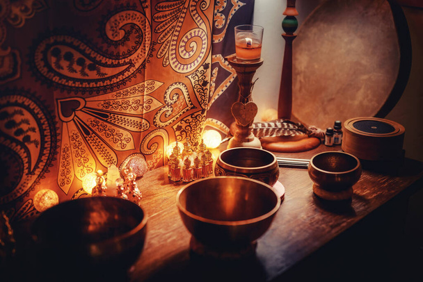 A closeup of perfumes bottles in candlelight and tibetan bowls - Foto, immagini