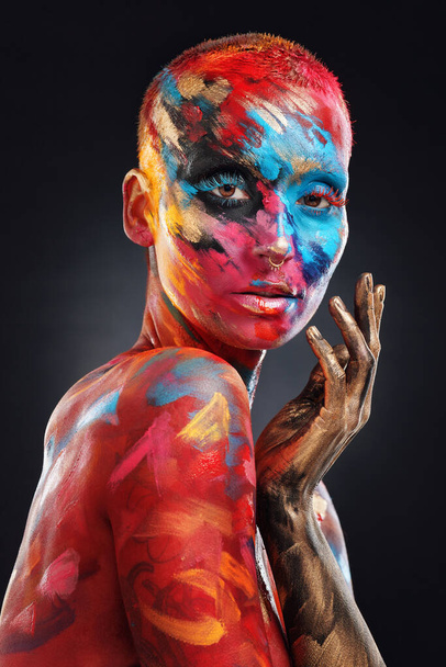 I choose to be eccentric. an attractive young woman posing alone in the studio with paint on her face and body - Fotó, kép