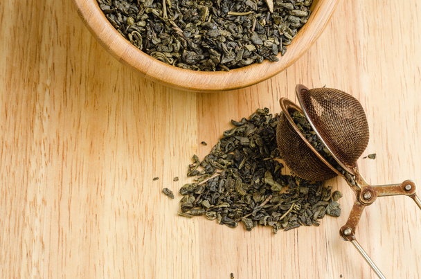 Zielona herbata, suszone liście z filtrem, na tle drewniane - Zdjęcie, obraz