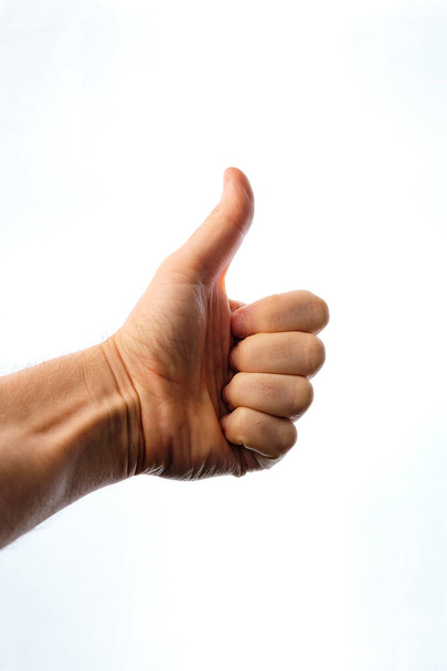 Man's hand with thumbs up, making the ok symbol, on a white background. - Fotó, kép