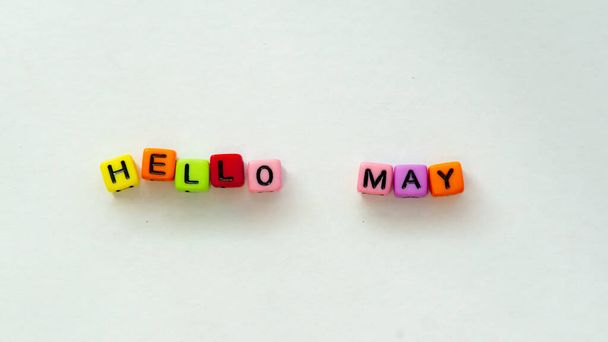 May coming and changing April. Spring concept. Colorful letter beads on white background. . High quality photo. Top view. Horizontal greeting postcard. Mock up template copy space. - Photo, Image
