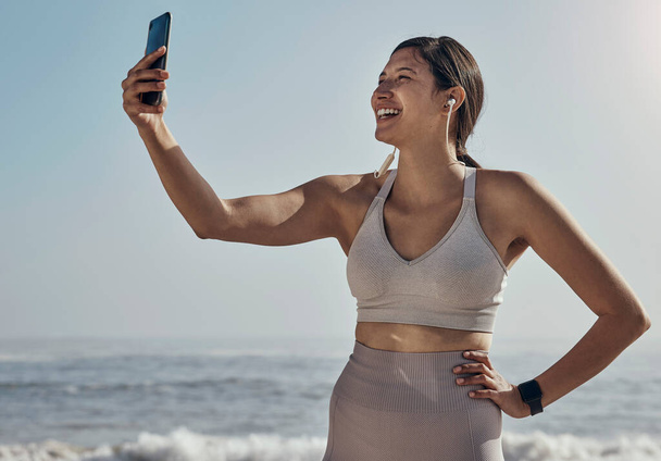 Fitness, selfie a žena na pláži na jógu, trénink a cvičení na pozadí modré oblohy. Sociální média, live streaming a cvičení vliv ženské nahrávání pro blog, post nebo profil obrázek. - Fotografie, Obrázek