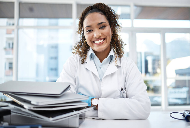 Doctor, documents and portrait of healthcare professional with paperwork on desk or table in the office smile and happy. Medical, research and medicine student studying and learning for knowledge. - Foto, imagen