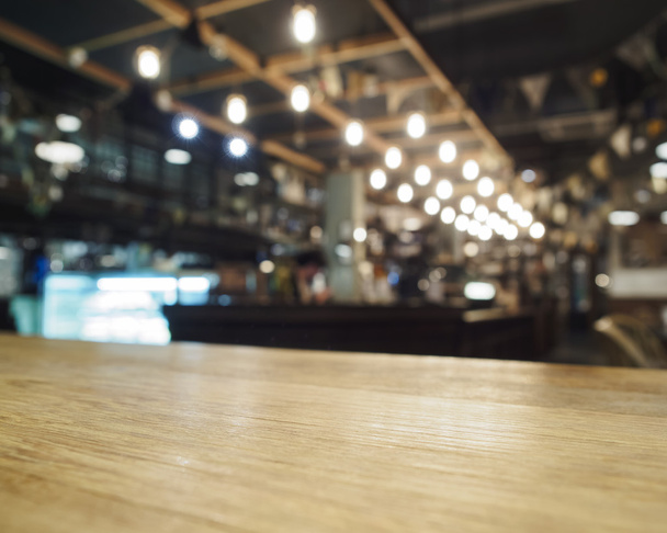 Parte superior de la mesa de madera con bar borrosa restaurante café fondo
 - Foto, Imagen