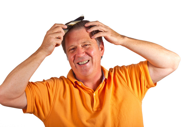 Attractive man combing his hair - Фото, изображение