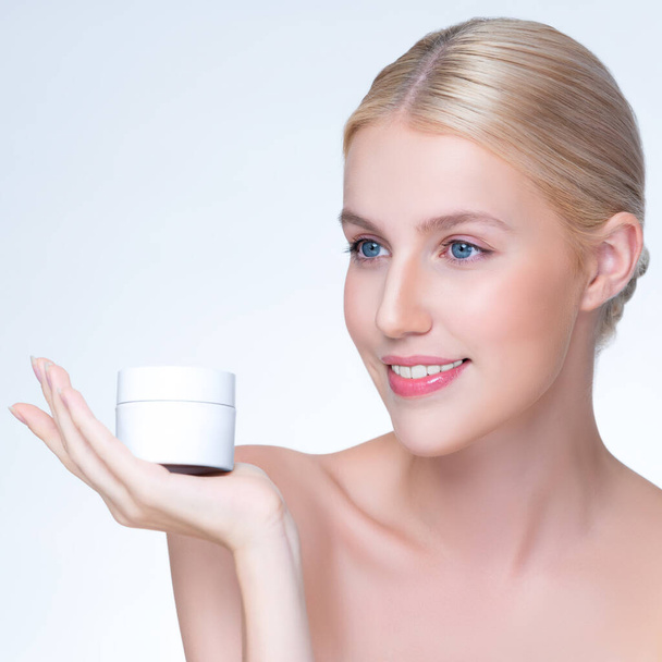 Personable beautiful perfect natural skin woman hold mockup tube moisturizer cream for skincare treatment product advertisement in isolated background with expressive facial and gesture expression. - Фото, зображення