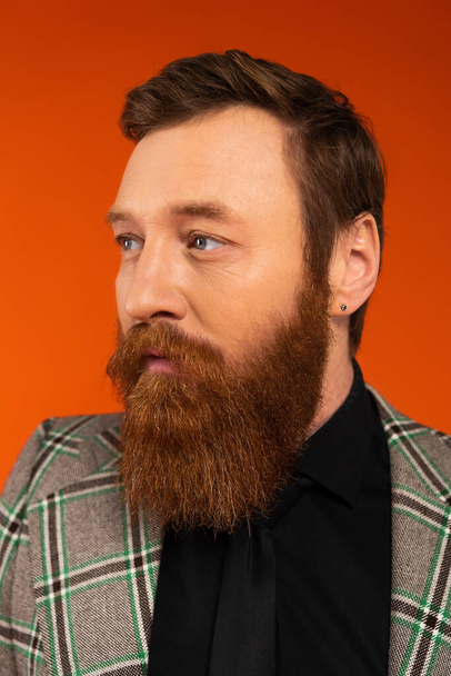 Portrait of stylish bearded man looking away isolated on red  - Zdjęcie, obraz