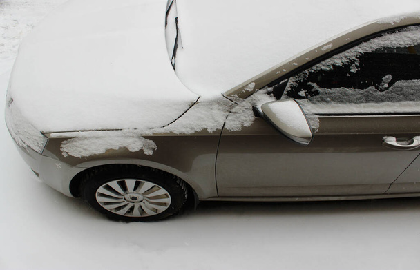 Капюшон и лобовое стекло автомобиля покрыты снегом - Фото, изображение