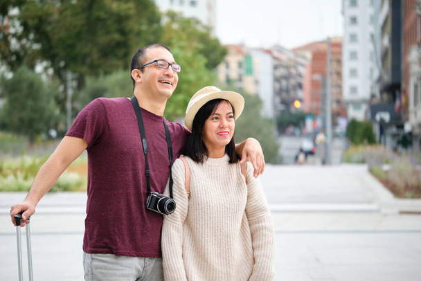Glückliches multiethnisches Touristenpaar, das gemeinsam die Stadt erkundet. Sightseeing in Madrid, Spanien. - Foto, Bild