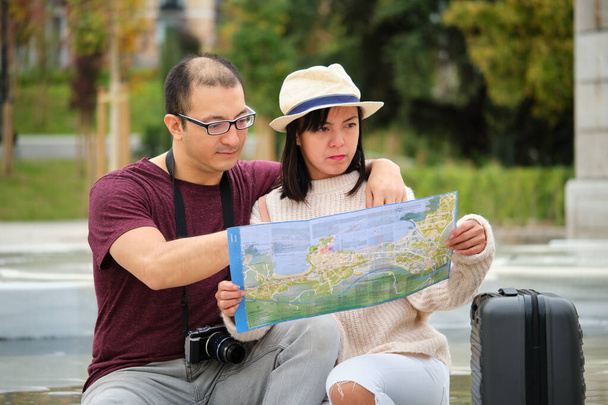 Multi-etnikai utazó pár használja a helyi térkép, hogy látogassa meg a várost. Turizmus Madridban, Spanyolországban. - Fotó, kép