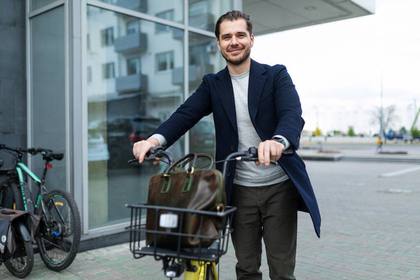 бизнесмен на велосипеде уезжает из офиса. - Фото, изображение