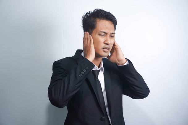 Unhealthy young asian man suffering from sudden throbbing ear ache. - Fotoğraf, Görsel