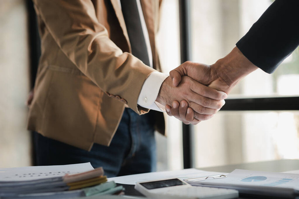 Business investor group holding hands, Two businessmen are agreeing on business together and shaking hands after a successful negotiation. Handshaking is a Western greeting or congratulation. - Photo, image