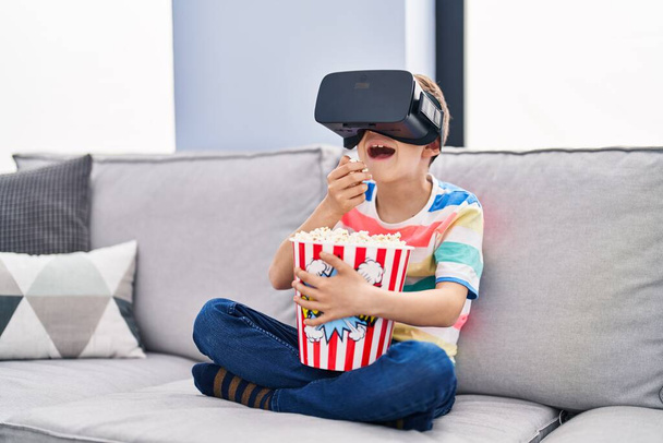 Ξανθό παιδί βλέποντας ταινία από γυαλιά εικονικής πραγματικότητας στο σπίτι - Φωτογραφία, εικόνα