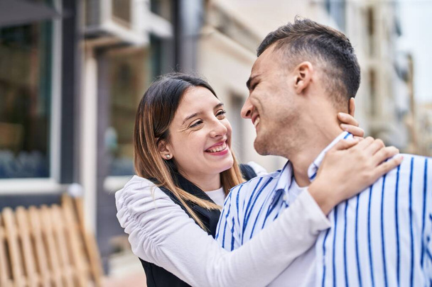 Mies ja nainen pari hymyilee luottavainen halaamalla toisiaan kadulla - Valokuva, kuva
