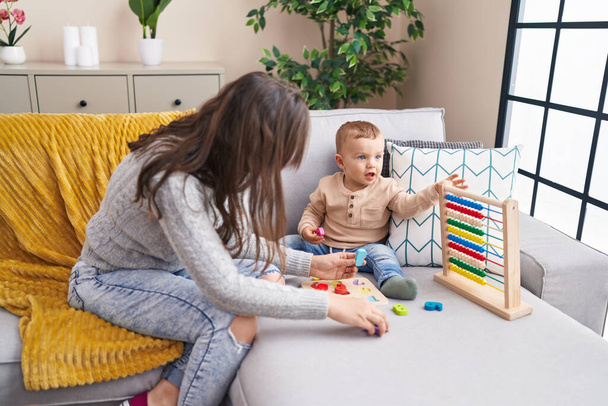 Matka a syn hrát s Abacus a matematiky puzzle hry sedí na pohovce doma - Fotografie, Obrázek