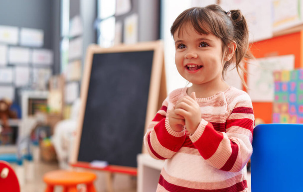 Adorable hispanic girl smiling confident standing at kindergarten - 写真・画像