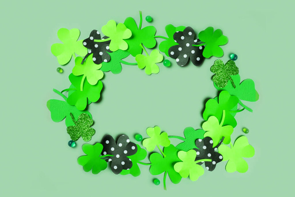 St. Patrick's Day frame background. Paper clover leaves on colored background with copy space. - 写真・画像