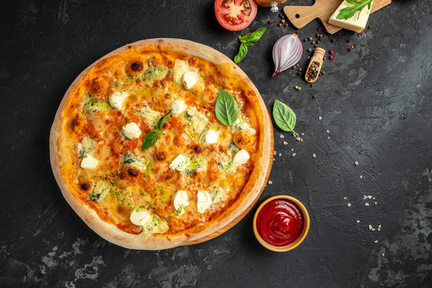 チーズピザ4個自家製イタリアンピザ。素朴な黒の背景にピザ。伝統的なイタリア料理。テキスト、トップビューの場所. - 写真・画像