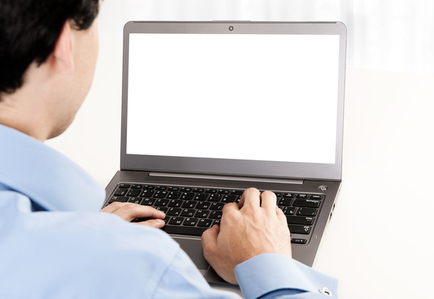 Rear view of young man working with laptop - Zdjęcie, obraz