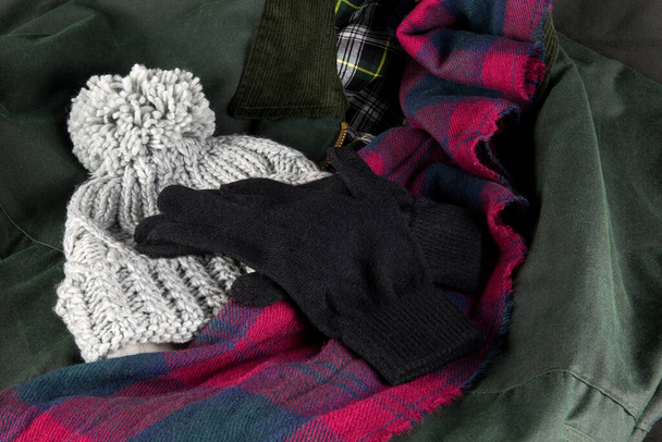 Handschuhe Mütze und Schal Outdoor-Bekleidung auf einem Wintermantel - Foto, Bild
