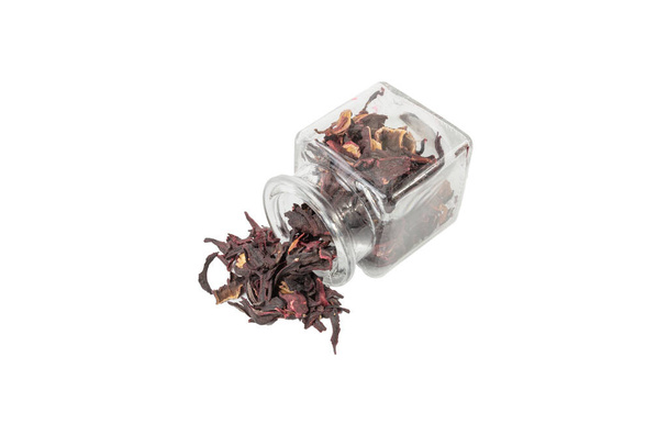 Dry hibiscus tea falling from glass jar isolated on white background. herb. herbal tea. food ingredient. - Fotó, kép