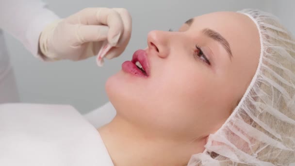 close-up, female lips. Surgeon, in medical gloves, carefully and slowly injects hyaluronic acid into woman's lips with a syringe. lip augmentation procedure. beauty injections. Plastic surgery. - Filmagem, Vídeo