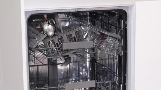 A mosogatógépből fényesen kimosott edények kirakodásának folyamata, miután kimosta azokat. - Felvétel, videó