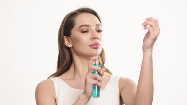 Jeune femme pulvérisant de l'eau micellaire sur le visage. Beauté femme en utilisant une bouteille hydratante pour pulvériser le visage. Soin féminin. Fille visage procédure de nettoyage de la peau le matin
 - Séquence, vidéo