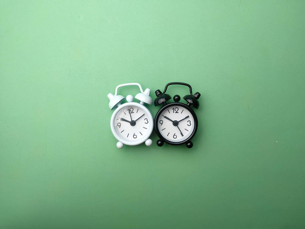 Top view Black and white alarm clock on a green background - Photo, Image