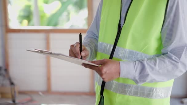 inspector or engineer is inspecting construction and quality assurance new house using a checklist. Engineers or architects or contactor work to build the house before handing it over to the homeowner - Filmagem, Vídeo