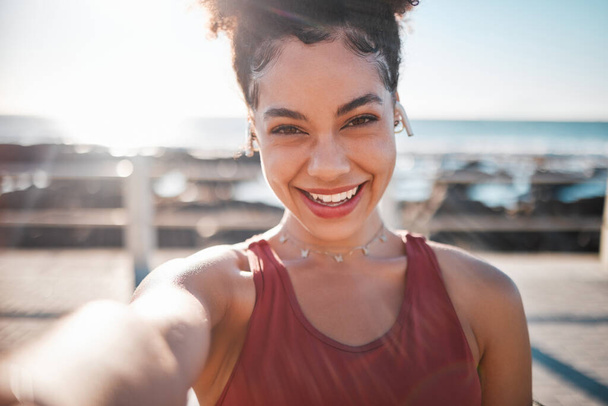 Fitness, schwarze Frau und Porträtlächeln für Selfie, Vlog oder Profilbild am Strand für Lauftraining. Glückliche afroamerikanische Läuferin lächelt für soziale Medien, Erinnerungen oder Post von der Küste. - Foto, Bild