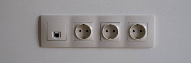 Electric socket on white wall closeup. Sockets with antenna cable and internet concept - Foto, imagen